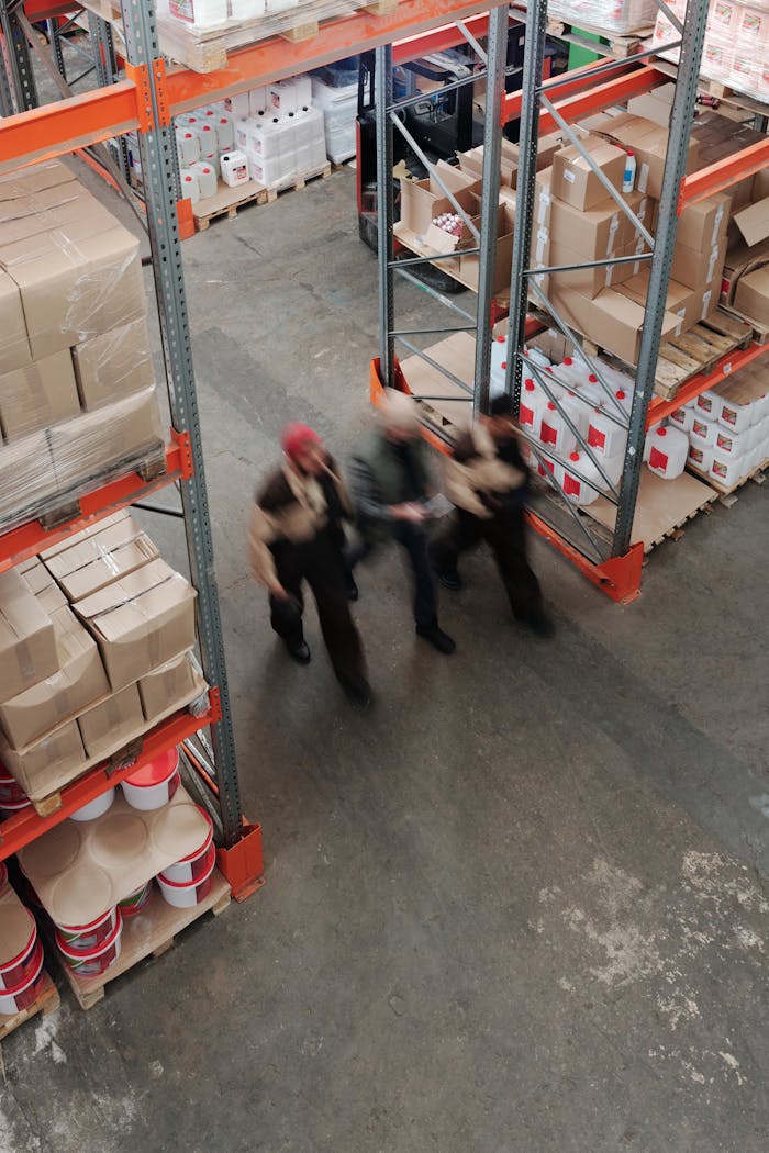 Blurred motion of workers managing inventory in a warehouse.